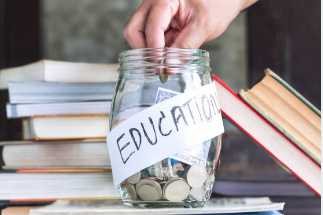 A hand putting money in a jar marked Education