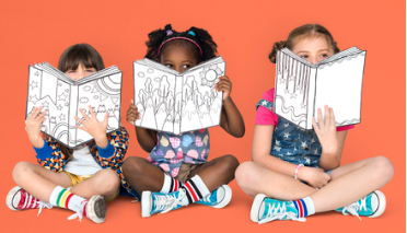 3 children sitting with crossed legs and each reading a book