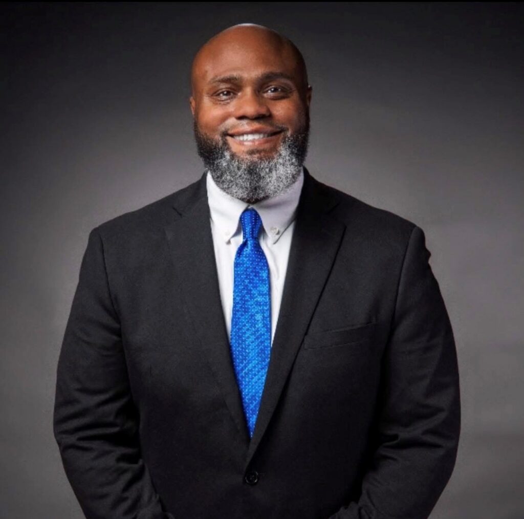 Smiling Black man with graying beard and wearing a business suit