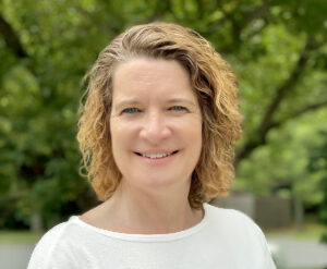 Fair-skinned woman with light-colored har smiling at the camera